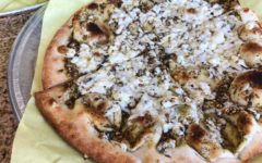 Flatbread topped with melted feta cheese and dark spices at Al Amir Bakery