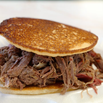 Shredded BBQ mutton is sandwiched between corncakes