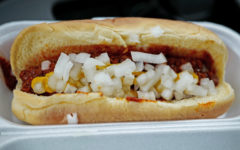 Styrofoam container holds hot dog bun filled with chili, onions, and mustard ... but no hot dog