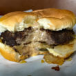 A bitten burger reveals molten cheese inside. ... molten cheeseburger of Minneapolis