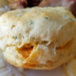 Biscuit dotted with herbs sandwiches melting cheddar cheese