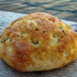 Rosemary speckles the crust of a round, high-rise focaccia.