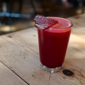 Cup filled with dark red beet-apple-ginger juice