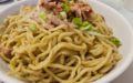Dry noodles sprinkled with BBQ pork, sprouts, and scallions