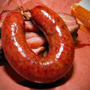 Thick, horseshoe-shaped sausage ring is tightly cased.