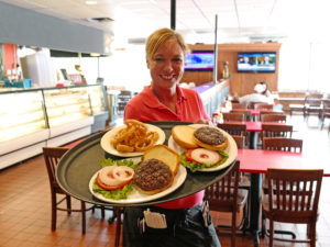 Waitress sows a tray of hamburgers