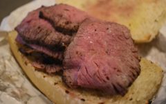 Pitmaster tends tri-tip beef on the grill