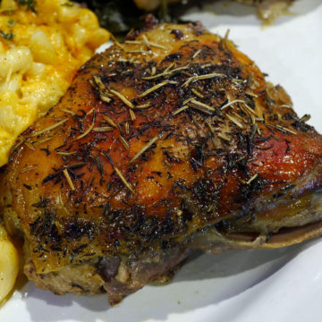 Red-gold baked chicken breast is spangled with rosemary