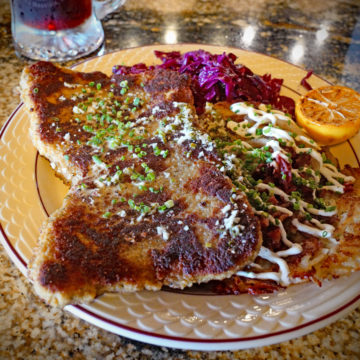 Wiener schnitzel plate includes a potato pancake and red cabbage
