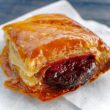Flaky square pastry with a sugar glaze an dark red guava filling