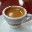 Small, thick white cup holds deep tan, foamy coffee ... Cuban eats in Little Havana
