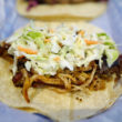 Pulled pork, slaw & beans are piled atop a broad tortilla.