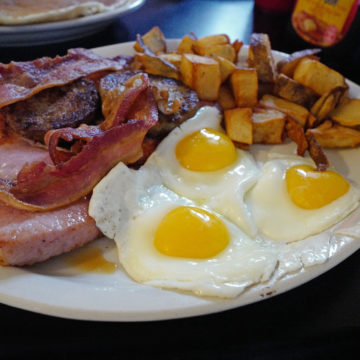 Plate crowded with breakfast of eggs, potatoes, bacon, sausage, and ham ... sweet Ozark eats