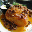 Sticky bun, crowded with nuts, wallows in a pool of caramel syrup.