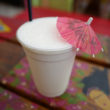 Styrofoam cup holds a lightly lime colored milk shake decorated with a pink parasol ... Key West treasure