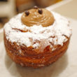Cuban coffee donut is dusted with powdered sugar and filled with coffee-flavored custard