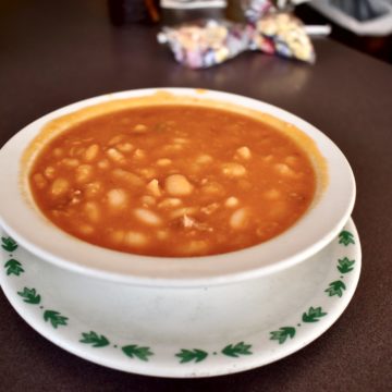 Orange soup packed with beans on a diner counter
