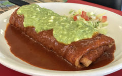 Crisp-fried chimichanga is smothered with red chile sauce and topped with guacamole.