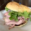 Pink, freshly-sliced ham is furled in a bun with plenty of green lettuce