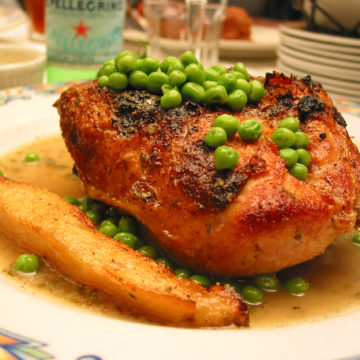 Chicken breast topped with peas and sided by potato logs