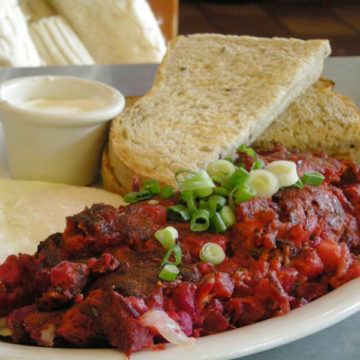 Red flannel corned beef hash is sprinkled with green onion bits.