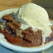 Grainy, dark russet pudding is topped with a scoop of vanilla ice cream