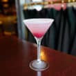 Slim-stemmed glass holds a pink lemon drop Martini
