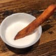 Sweet potato fry dips into a ramekin of Marshmallow Fluff
