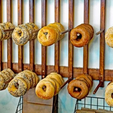 Freshly baked assorted bagels for sale, hung on wall pegs