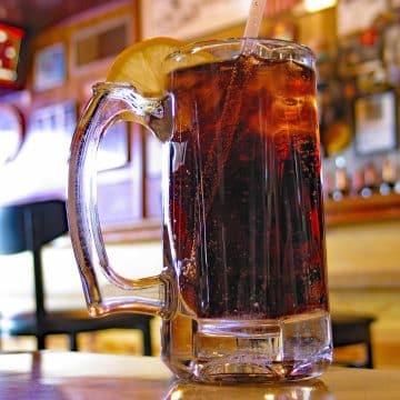Glass mug of Coca-Cola on a table in a bar