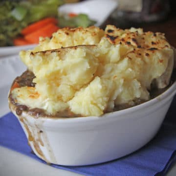 Deep oval casserole is piled high with mashed potatoes on top