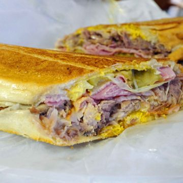 Pressed-flat sandwich squeezes roast pork, ham, Swiss cheese, pickles and mustard.