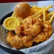 Chicken tender dinner is a basket includes French fries, roll, and dipping sauce.