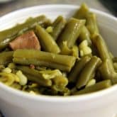 A cup of tender green beans, laced with bacon