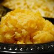 Large mound of corn pudding plays a supporting role on a disposable diner plate.