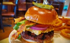 Pimento cheeseburger is draped with slices of bacon