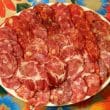 Large round plate holds a selection of thin slices of different salamis