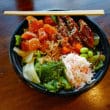 Poke bowl features bite-size pieces of salmon and eel.