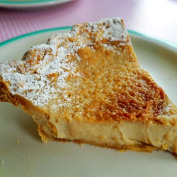 Fragile wedge of sunny yellow pie, its custard topped with a thin sugar crust