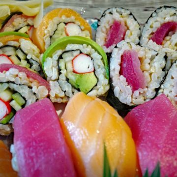 Sushi tray holds salmon, tuna, and surimi.