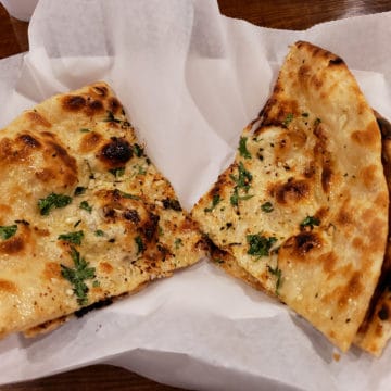 Glistening flatbread triangles are dotted with bits of garlic and herbs