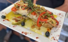 Plate of baked cod decorated with vegetables and herbs ... Portuguese seafood